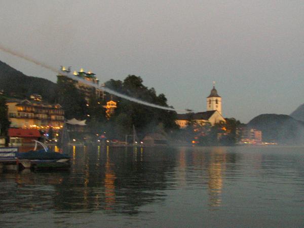 Art flier in deep flight over the white Roessl
The art flier pulls his smoke lane deep over St.Wolfgang and the famous white Roessl in late dawn.